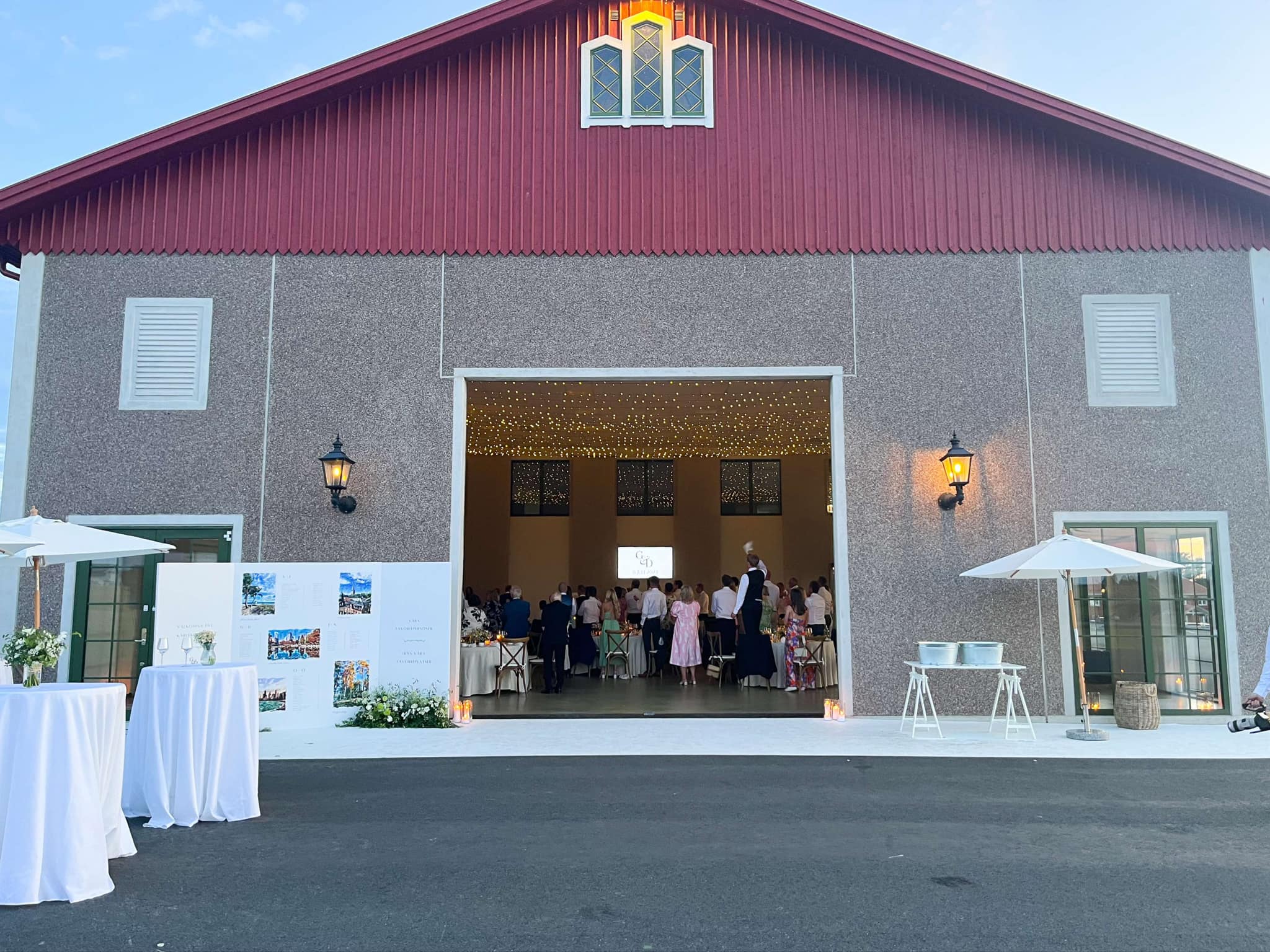 Vår stora mässhall stor öppen och gästerna roar sig. Ljusslinga lyser i taket.